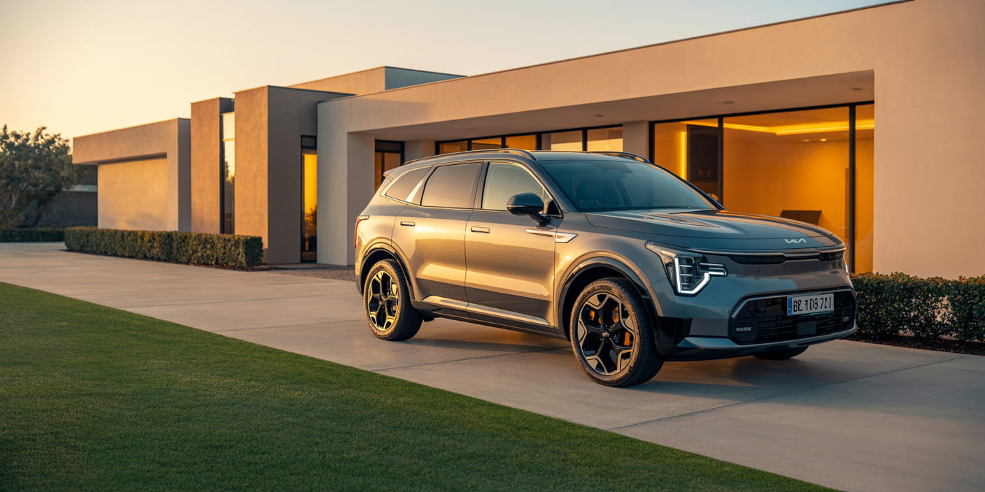 Modern electric SUV parked in front of contemporary home at golden hour
